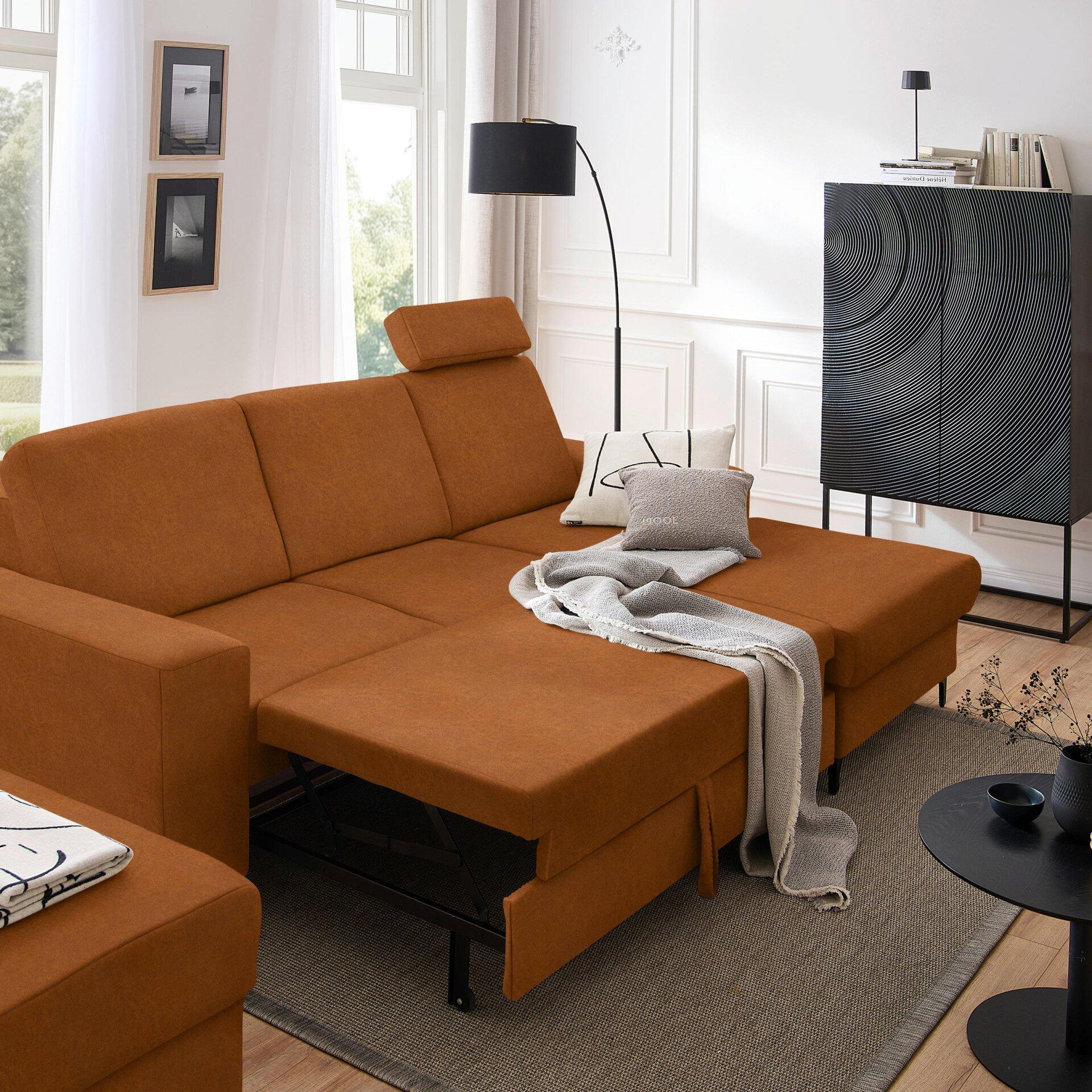 Ecksofa Balina in L-Form mit ausgeklappter Schlaffunktion und schlanken, schwarzen Metallfüßen, leicht seitliche Perspektive zur Darstellung der Eckanordnung.