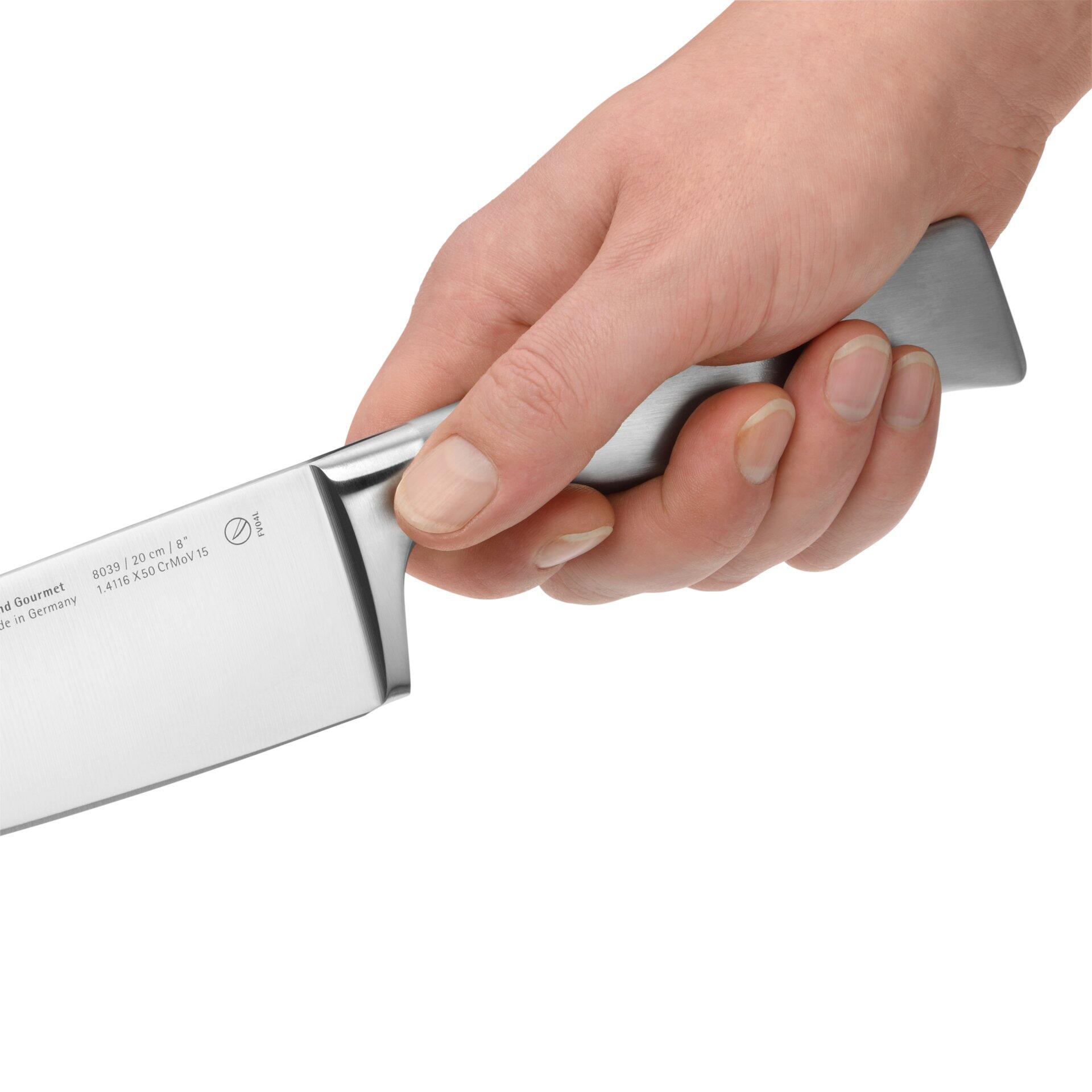 Kochmesser Grand Gourmet von WMF in der Hand, Detailaufnahme von unten, zeigt Klinge, Griff und ergonomische Form.