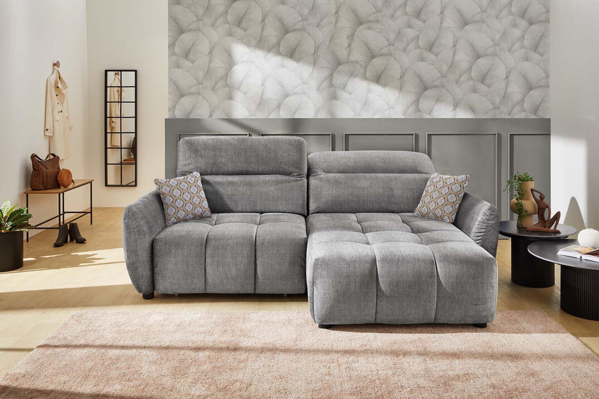 Wohnlandschaft Zoom mit ausgezogener Schlaffunktion und geometrischen Kissen, aus leicht erhöhter Perspektive im modernen Wohnzimmer.